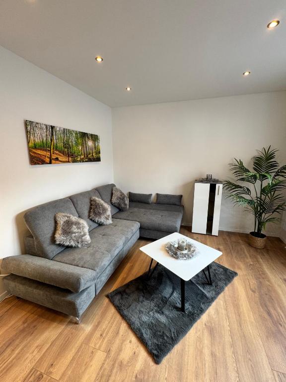 Wohnzimmer mit Sofa und Waldmotiv an der Wand