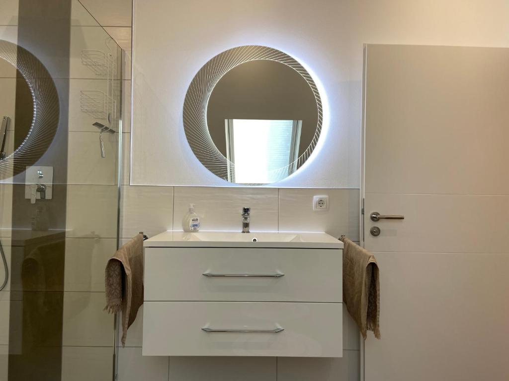 Badezimmer mit Waschtisch und beleuchtetem Spiegel